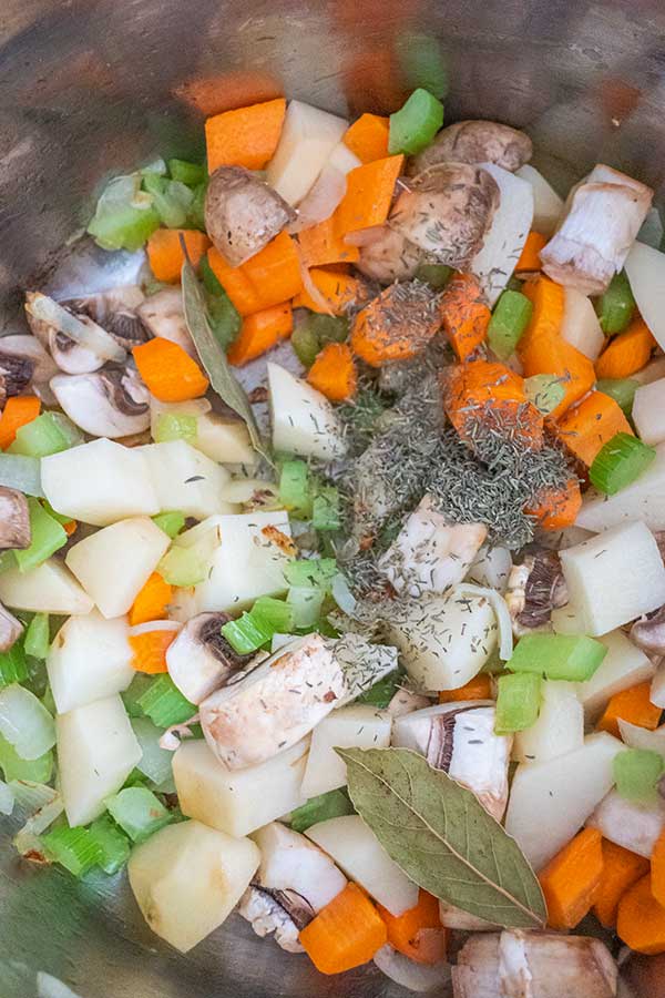 onions celery carrots mushrooms simmering in a pot