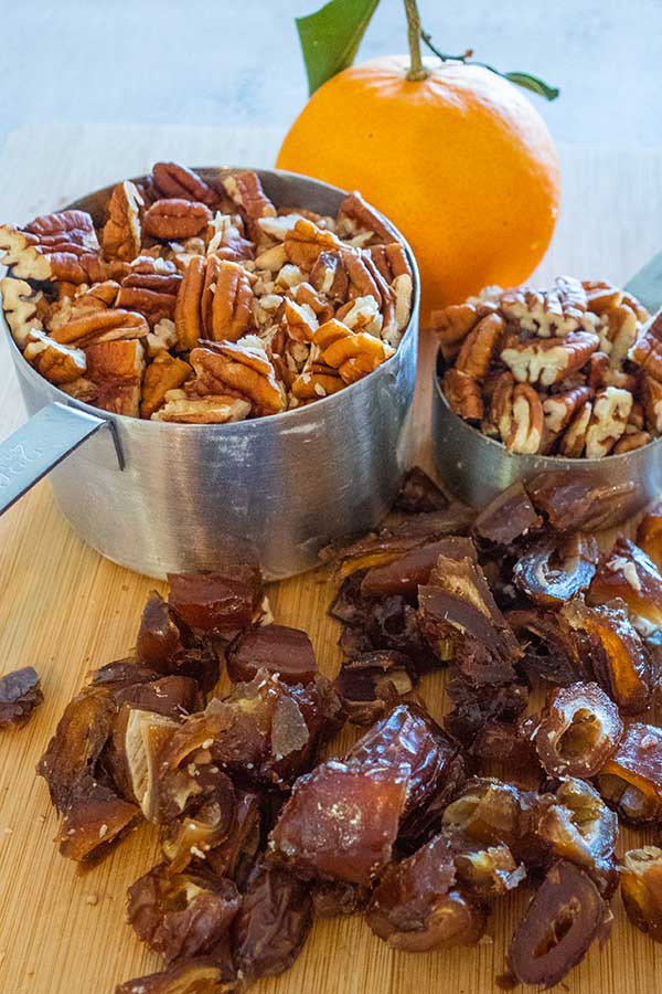 dates pecans and orange on a cutting board