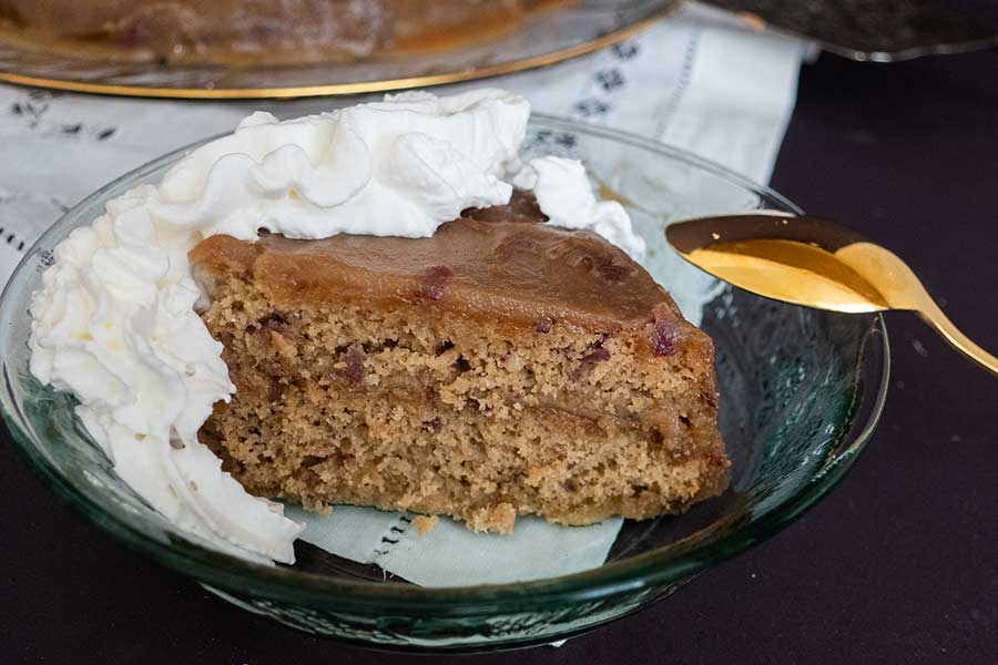 a slice of sticky toffee pudding snacking cake with whipped cream on a plate. Easter dessert