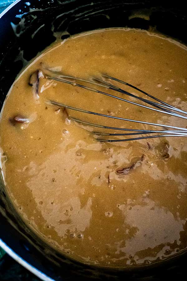 toffee sauce with a whisk in a saucepan