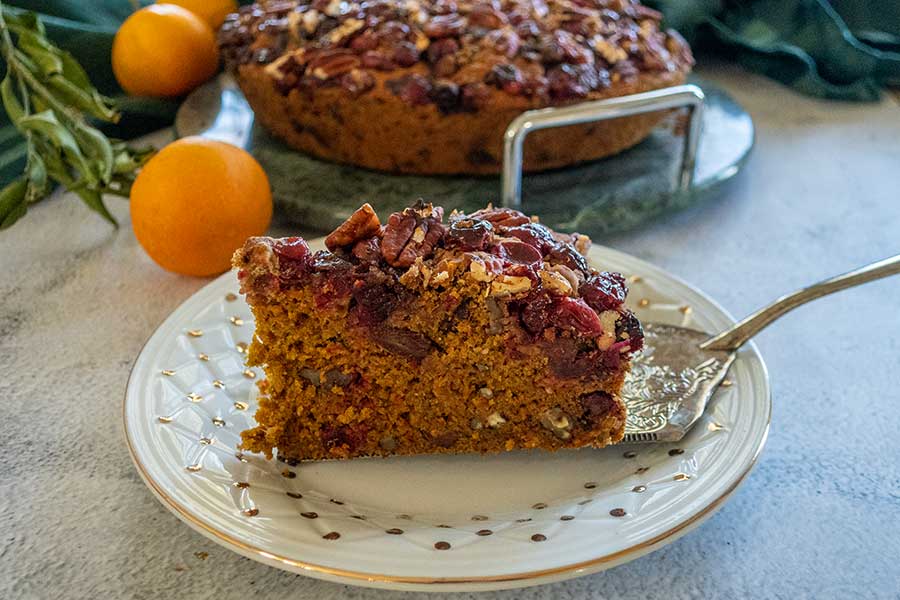 a slice of vegan cranberry christmas cake on a plate