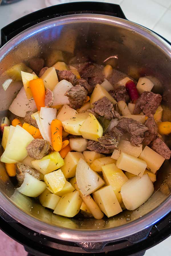 raw root veggies and cubed beef in an instant pot