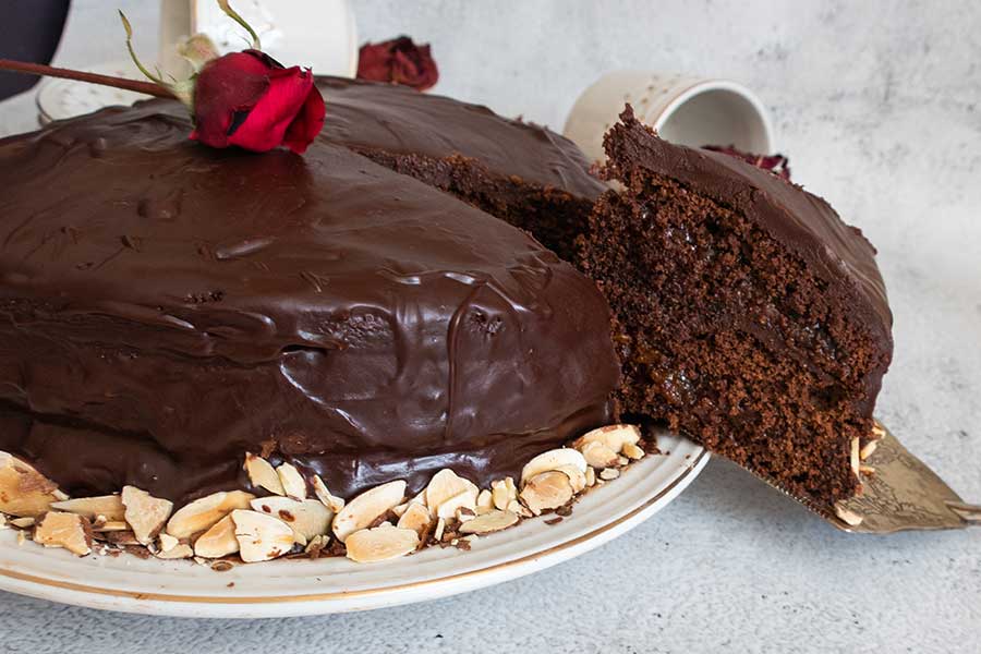 sacher torte on a platter with one piece cut out