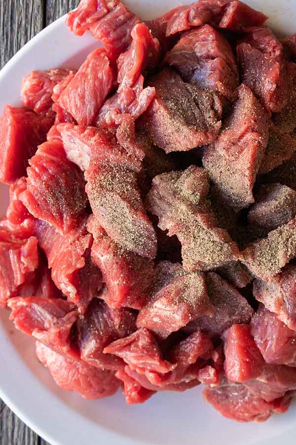 cubed raw stewing beef on a plate