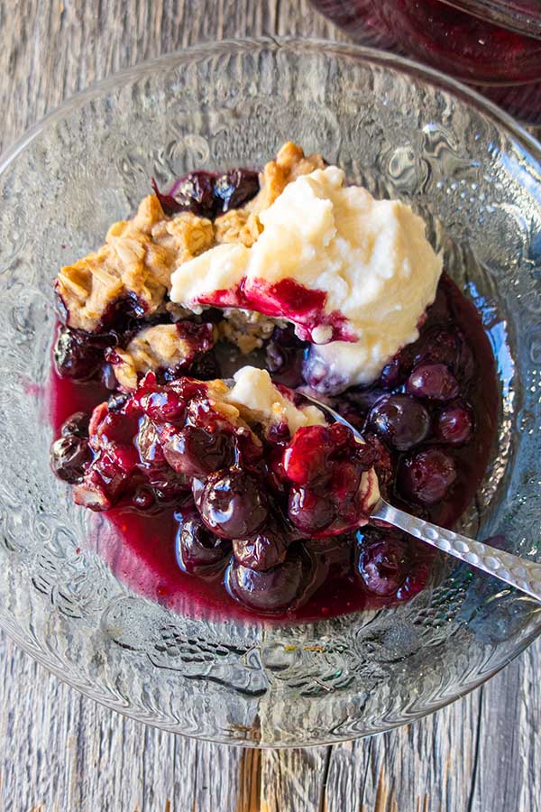 blueberry crumble in a bowl with spoon