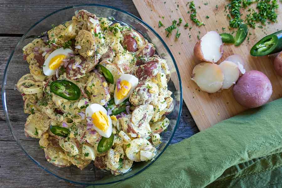 vegetarian texas potato salad with eggs, pickels and herbs in a bowl
