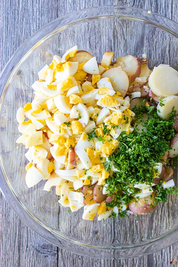 cooked potatoes and eggs with parsley in a bowl