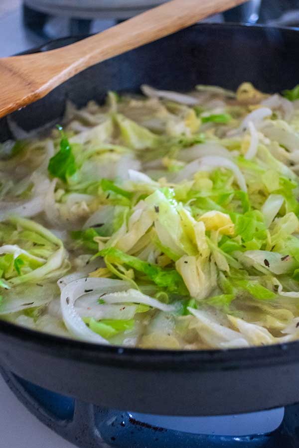 cabbage and onions cooking in a skillet