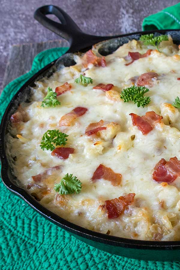 irish potatoes topped with cheese and bacon in a skillet
