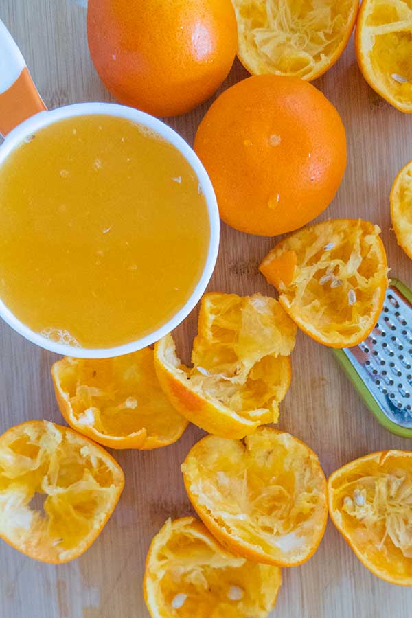 squeezed oranges and orange juice in a measuring cup