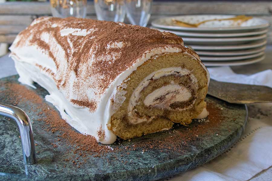 tiramisu swiss roll on a cake platter, gluten free