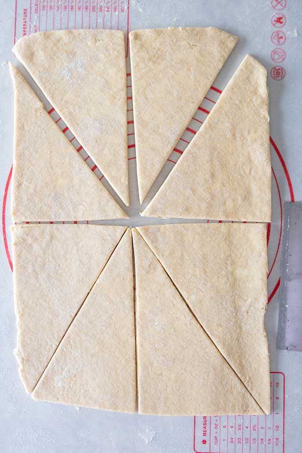rectangle shaped rolled dough sliced to rectangles on a pastry mat