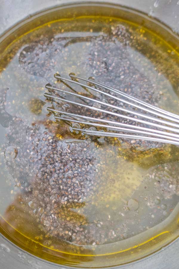 chia seeds, water, olive oil in a bowl with a whiisk