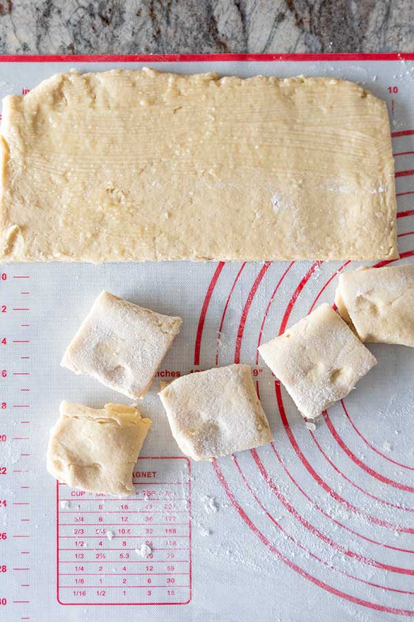 shaping dough into Parker house rolls on a pastry sheet