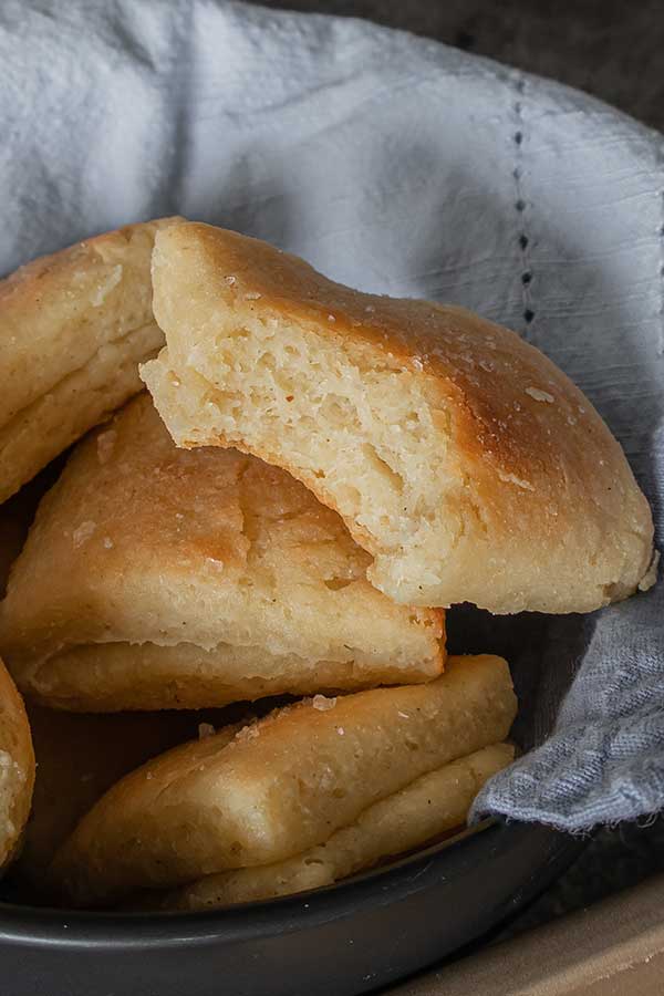 gluten free parker house rolls in a bowl lined with a towel