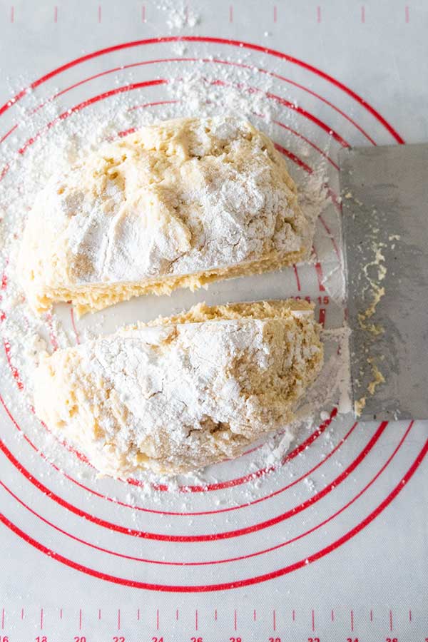 ball of gluten-free dough dusted with flour cut in half