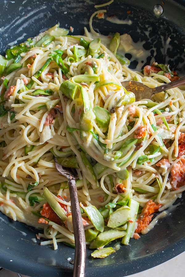 creamy smoked salmon and asparagus pasta in a skillet.