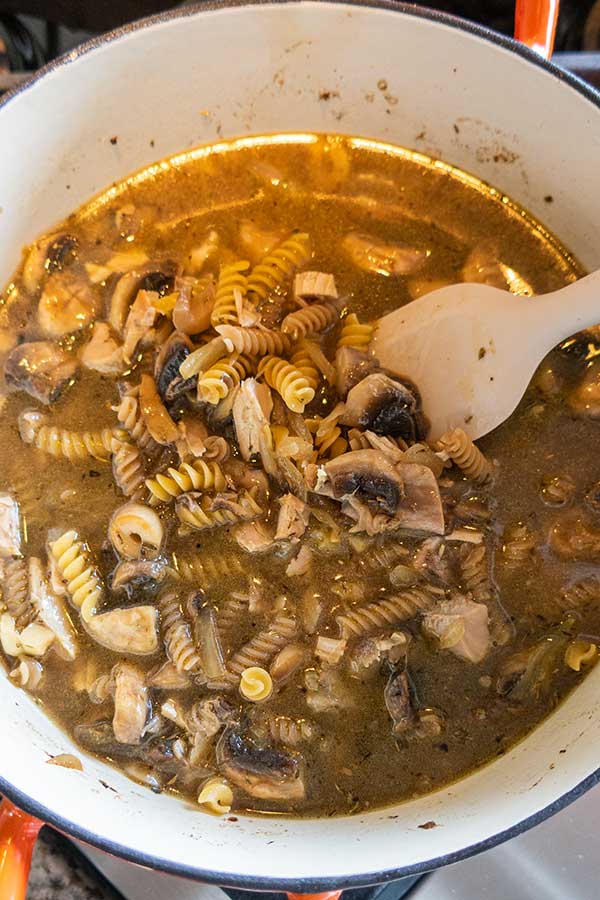 pasta in broth with mushrooms and turkey in a pot