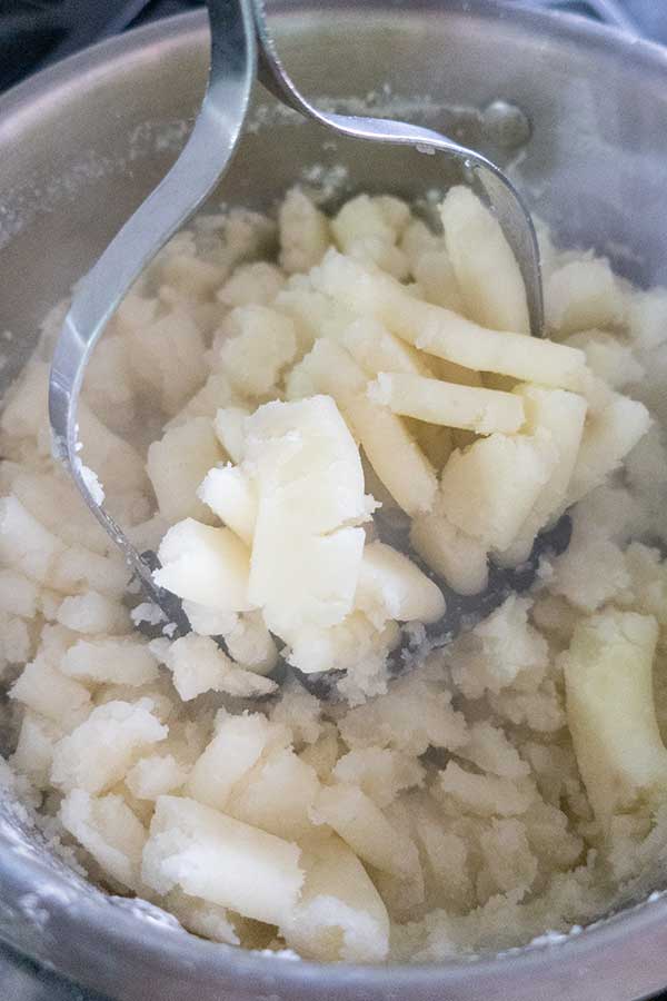 mashed potatoes in a bowl with masher