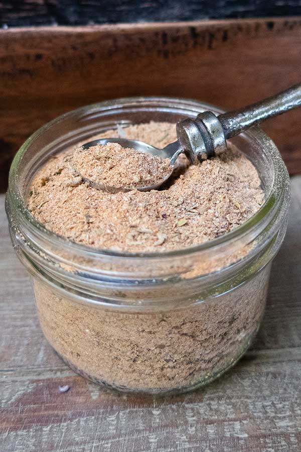 cajun spice mix in a glass container with a spoon