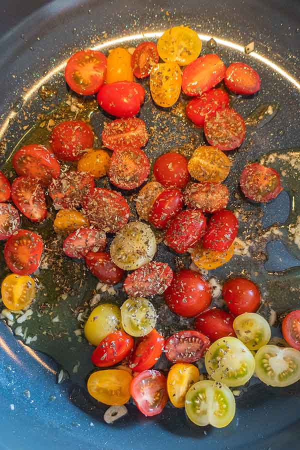 cherry tomatoes and garlic in a pan with olive oil