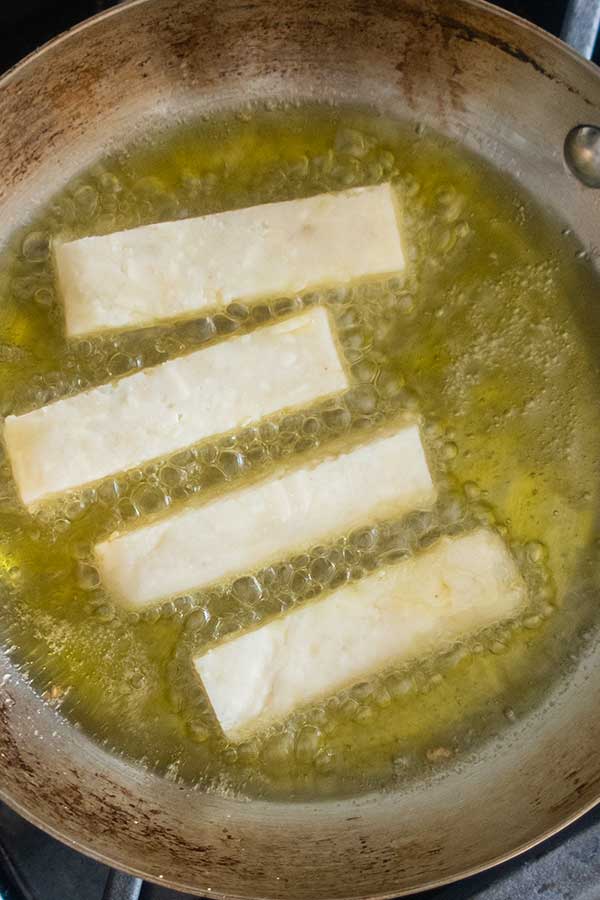 potato cheese sticks frying in a pan with oil