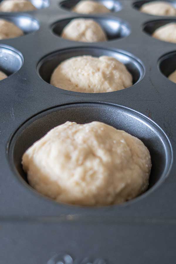 proofed gluten free donut dough in a muffin pan