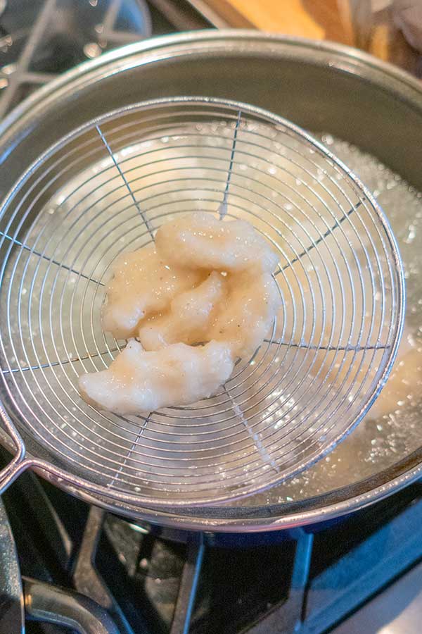 removing cooked gnocchi from boiling water