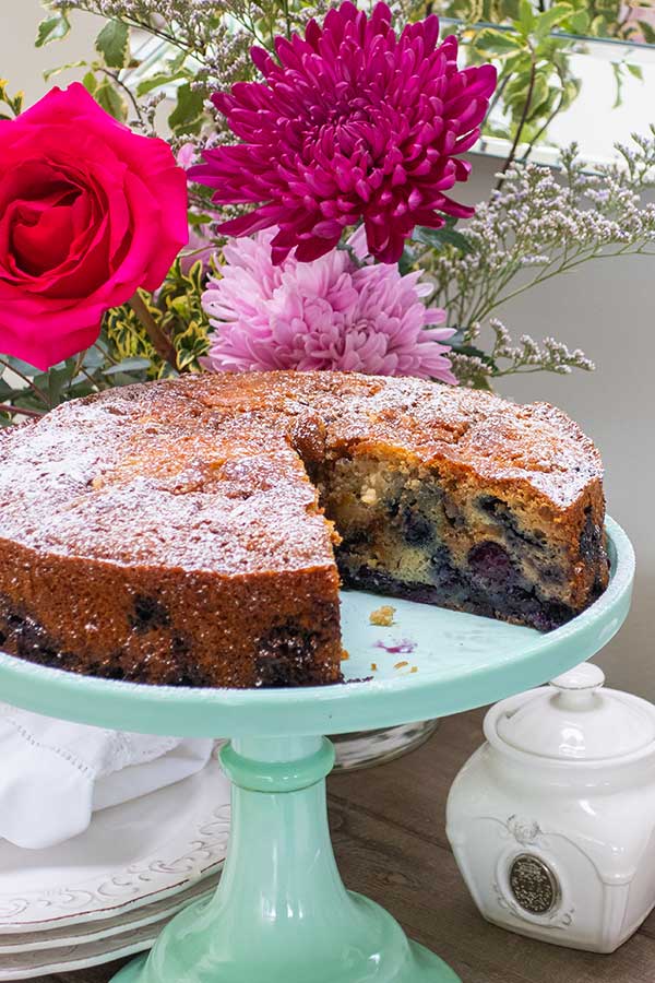 a slice missing in a baked snacking blueberry cake