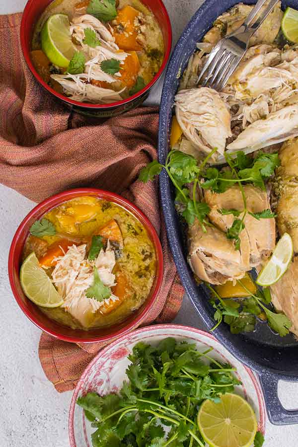 top view of bowls with thai soup and cooked chicken on a platter