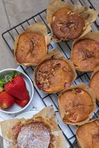strawberery muffins on a cooling rack with fresh berries in a cup, dairy free, gluten free