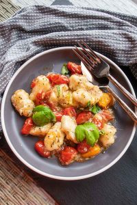 gluten free cheesy gnocchi with cherry tomatoes and basil