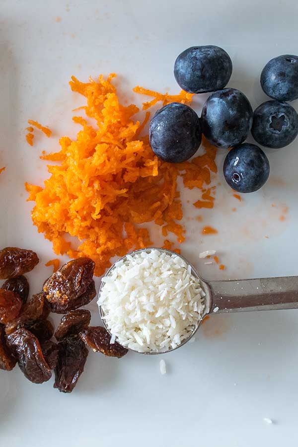 rasins, blueberries, grated carrots, grated coconut on a plate