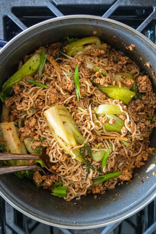 top view sambal pork noodles with bok choi in a sauce pan