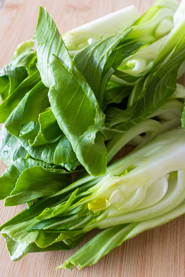 quartered raw bok choy on a cutting board