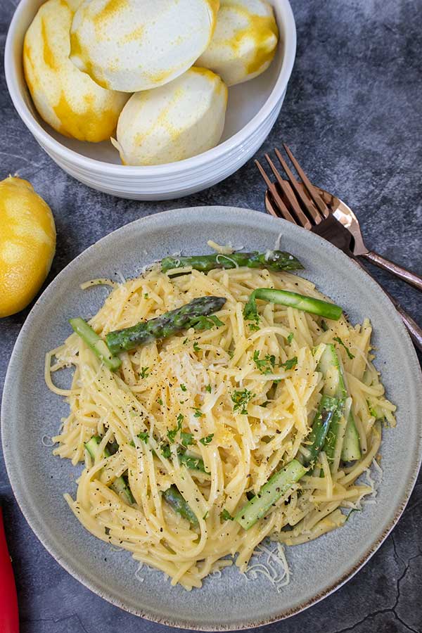 plated lemon pasta and zested lemons in a bowl