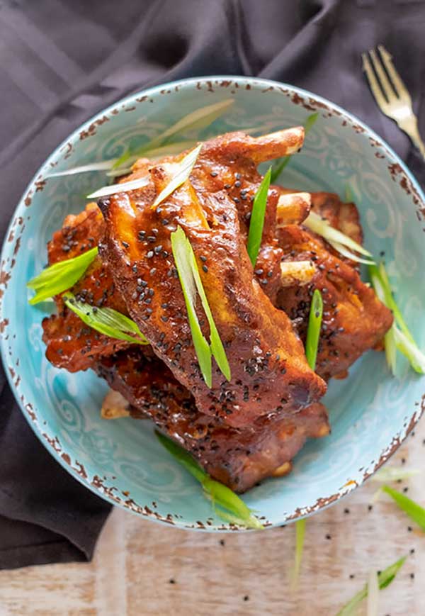 asian ribs on a plate topped with green onions