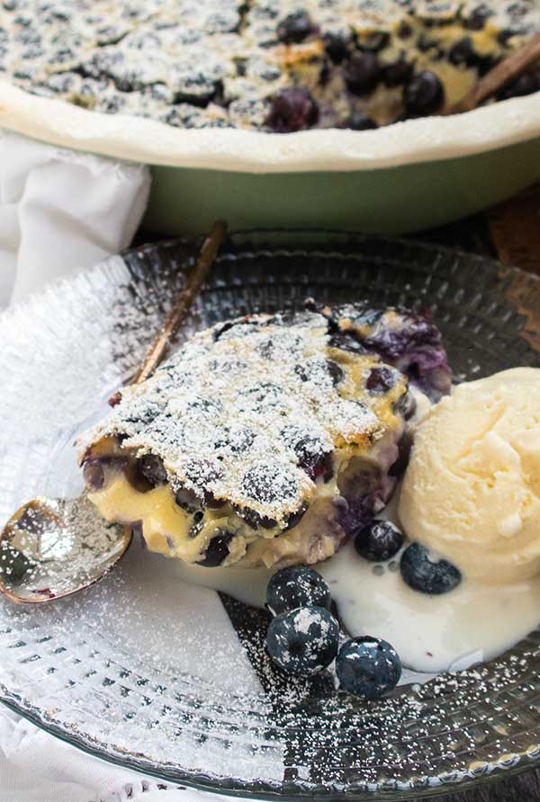 slice of clafoutis with melted ice cream on a plate