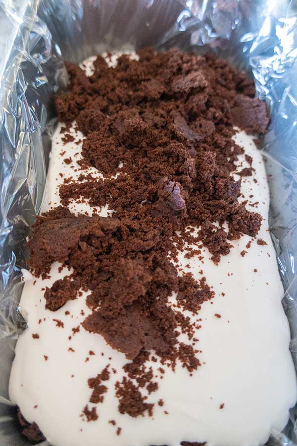 ice cream topped with brownie crumbs in a loaf pan