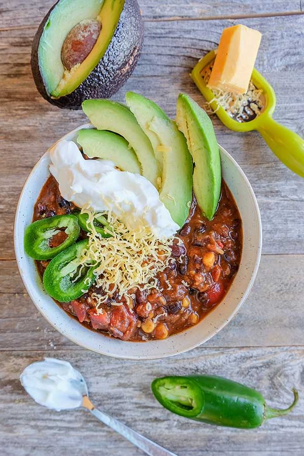 black bean chili in a bowl topped with avocado and sour cream