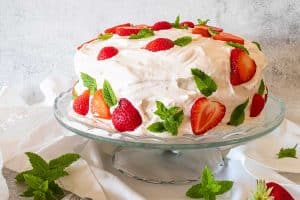 strawberry icebox cake decorated with strawberries on a cake platter
