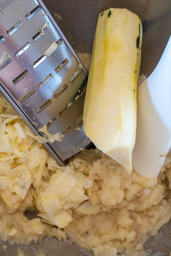 mashed bananas and grated zucchini in a bowl