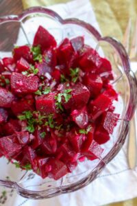 beet salad in a light vinaigrette topped with parsley in a clear bowl