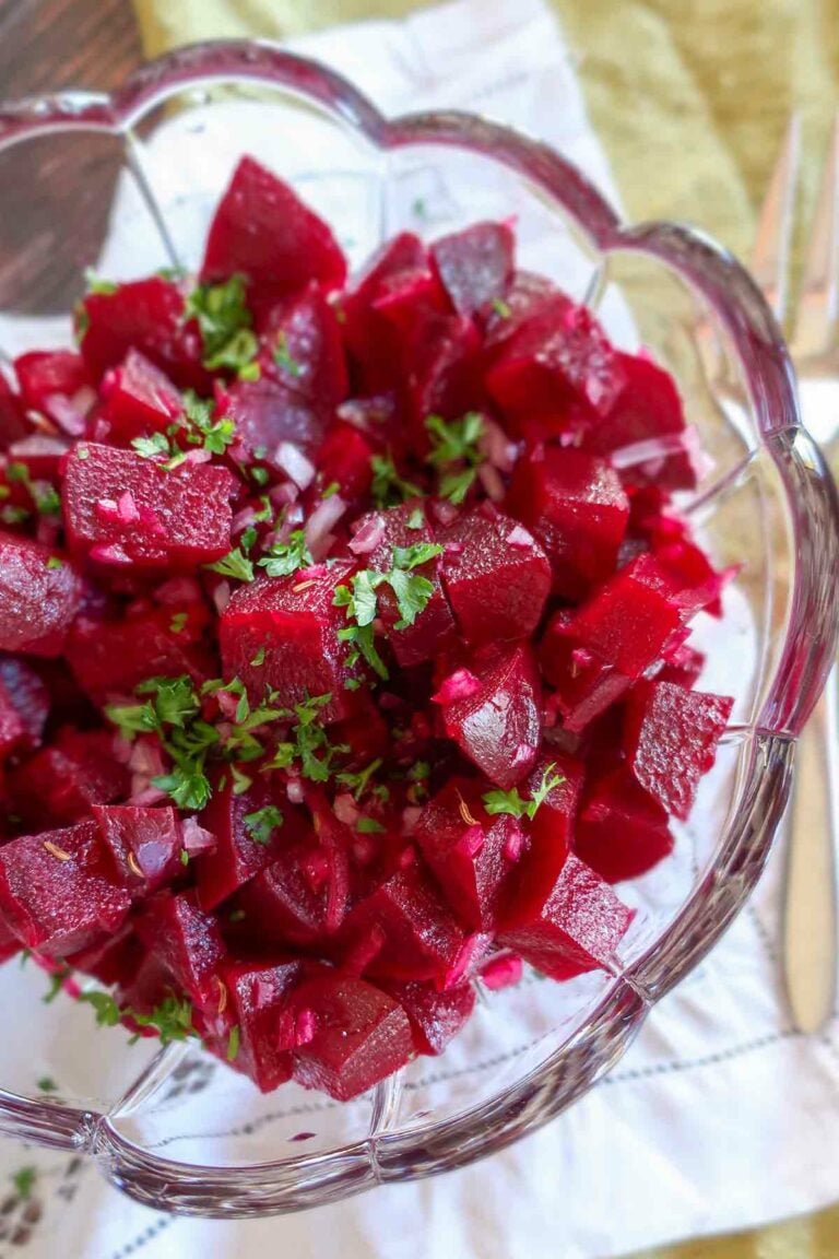 beet salad in a light vinaigrette topped with parsley in a clear bowl