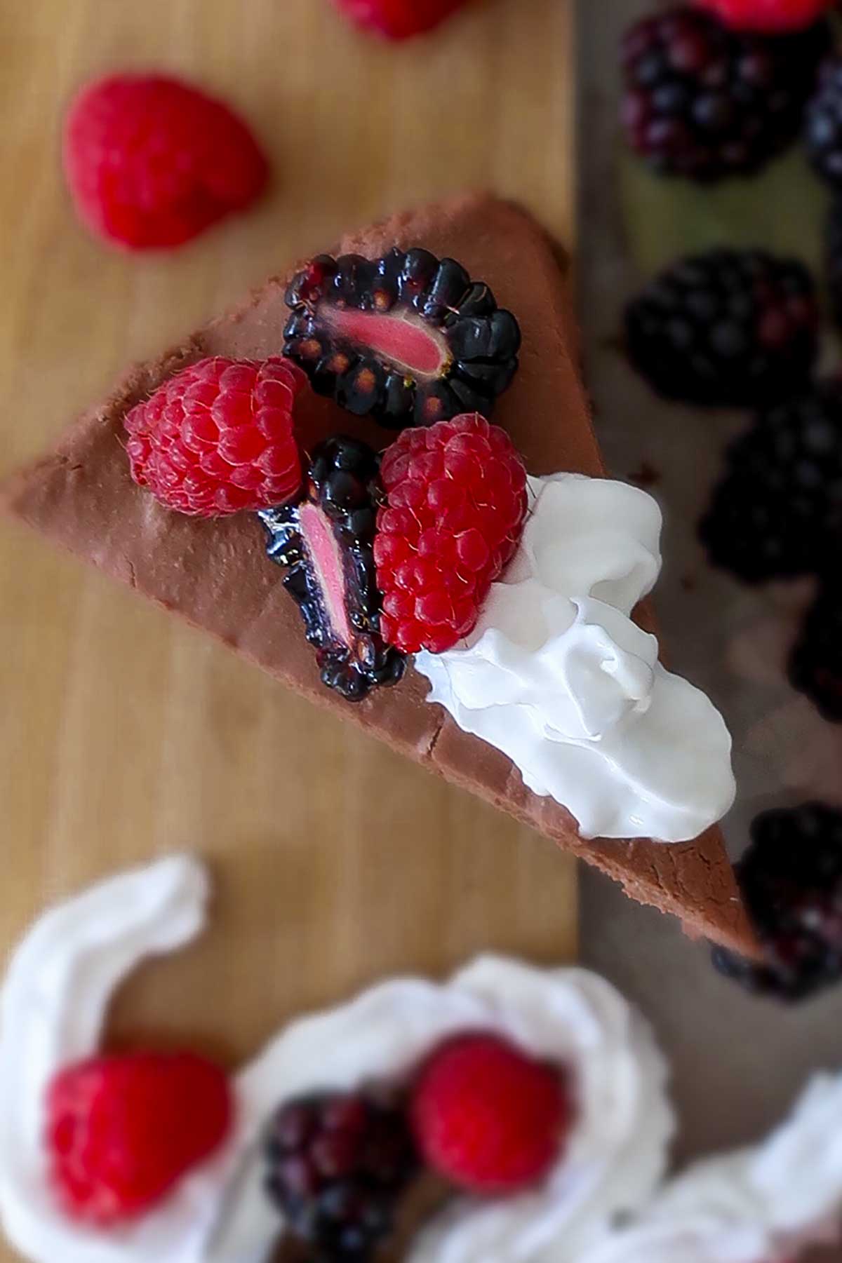 top view of chocolate mousse cake with berries and cream
