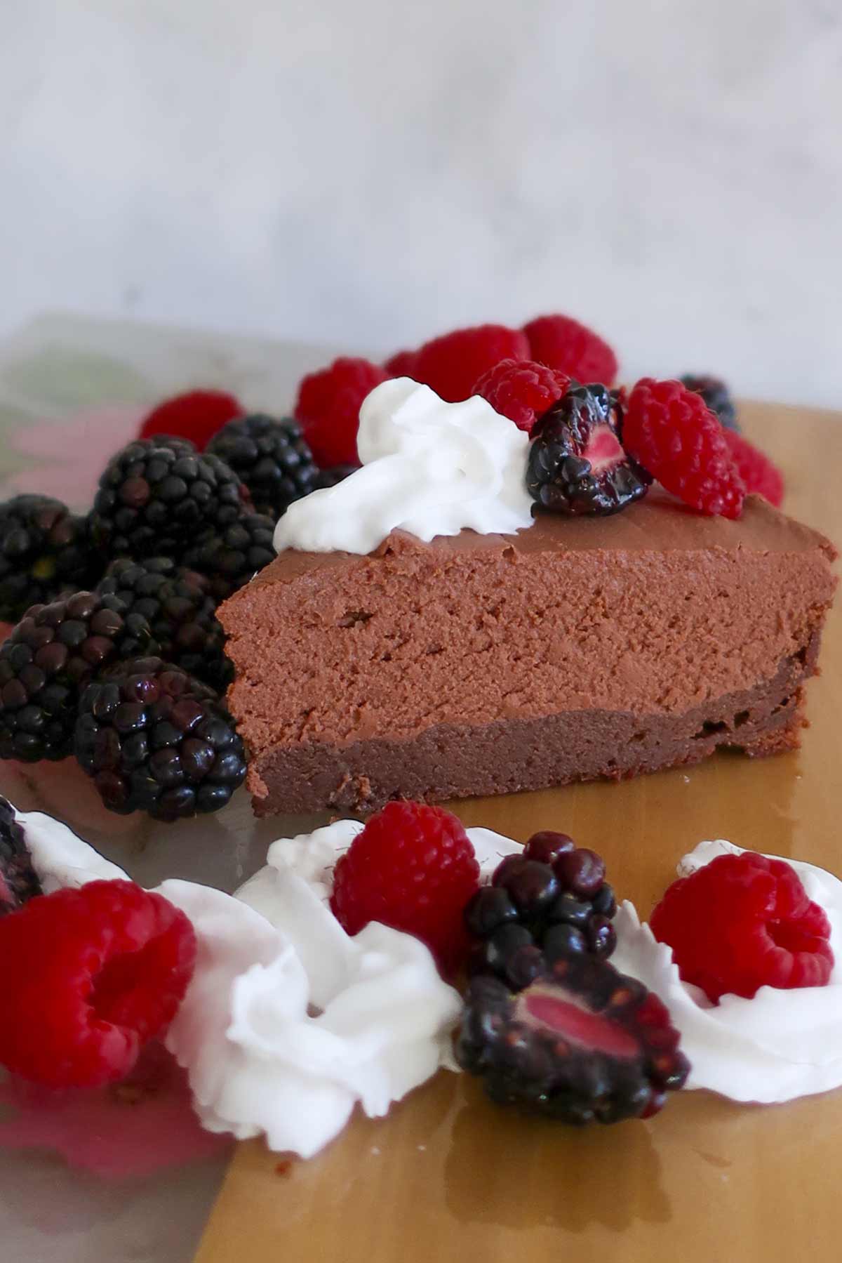 a slice of death by chocolate cake topped with cream and berries