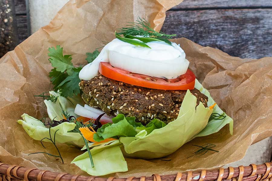 falafel burger made with chickpeas on a lettuce leaves topped with tomato and onion