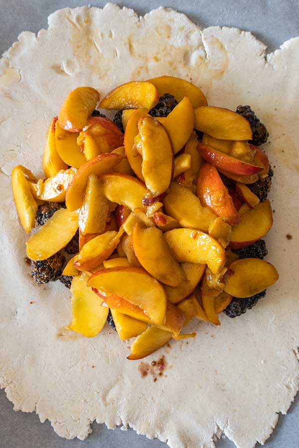 pie dough topped with blackberries and peaches