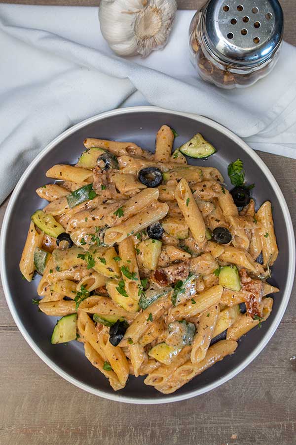 gluten free zucchini pasta with olives in a sauce on a plate