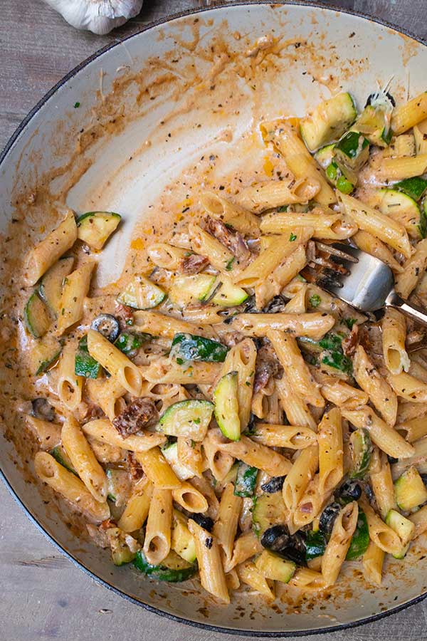 half filled skillet with Italian penne and sauce